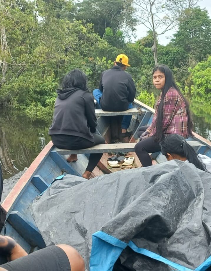 Jovens indígenas navegando pelo igarapé