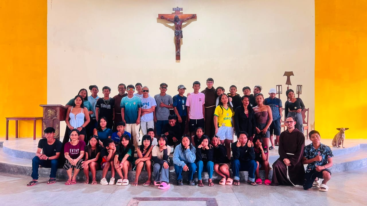 Foto do grupo do Encontrão Vocacional diante do crucifixo na capela