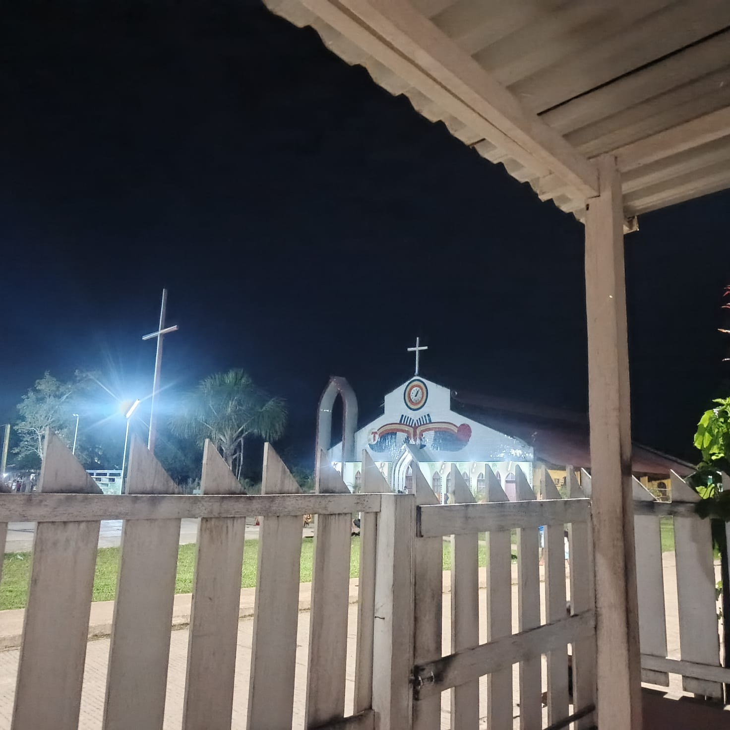 Igreja da comunidade iluminada à noite vista da varanda em frente