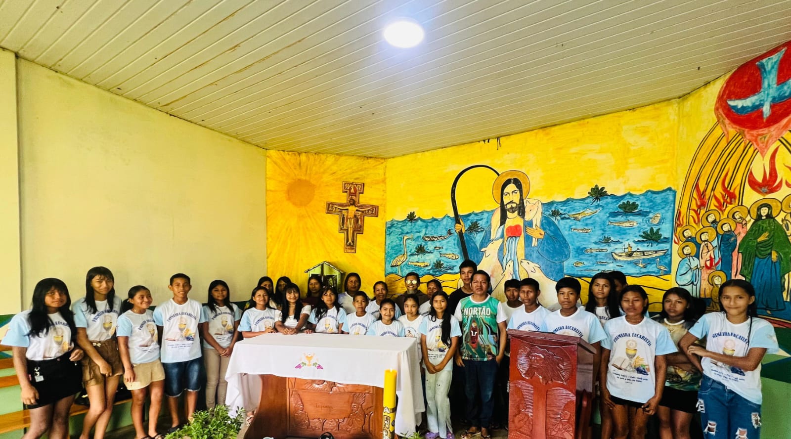 Jovens da comunidade reunidos junto ao altar para a Primeira Eucaristia
