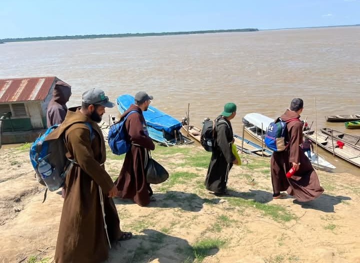 Frades capuchinhos chegando à beira do rio para embarcar em missão