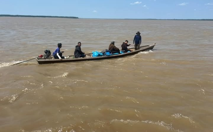Travessia de canoa pelo rio com missionários e mantimentos