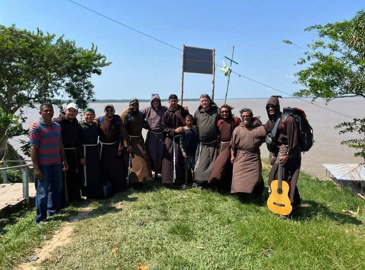 Grupo de frades capuchinhos reunido à beira do rio após viagem missionária